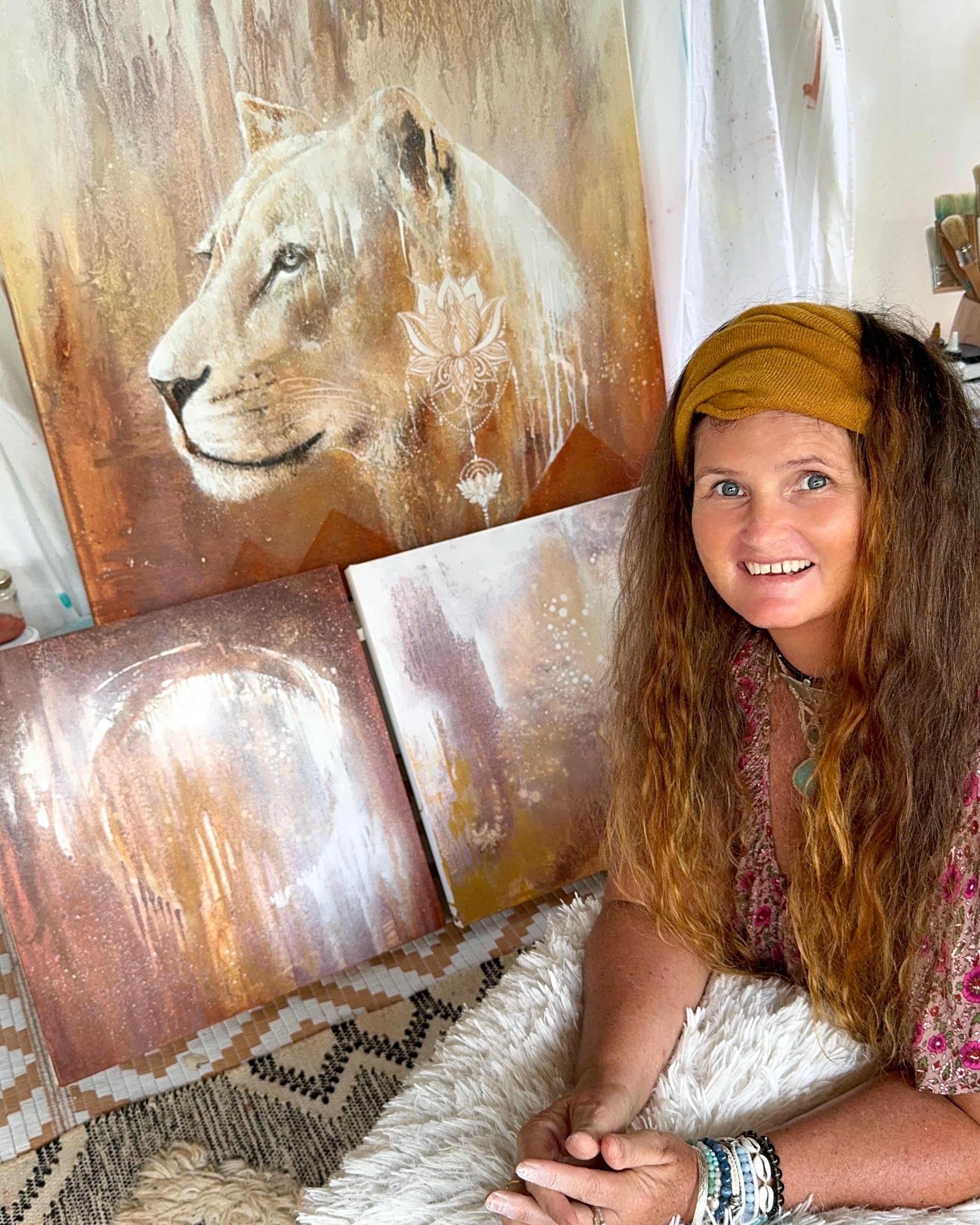Woman sitting in front of a wall with lion paintings