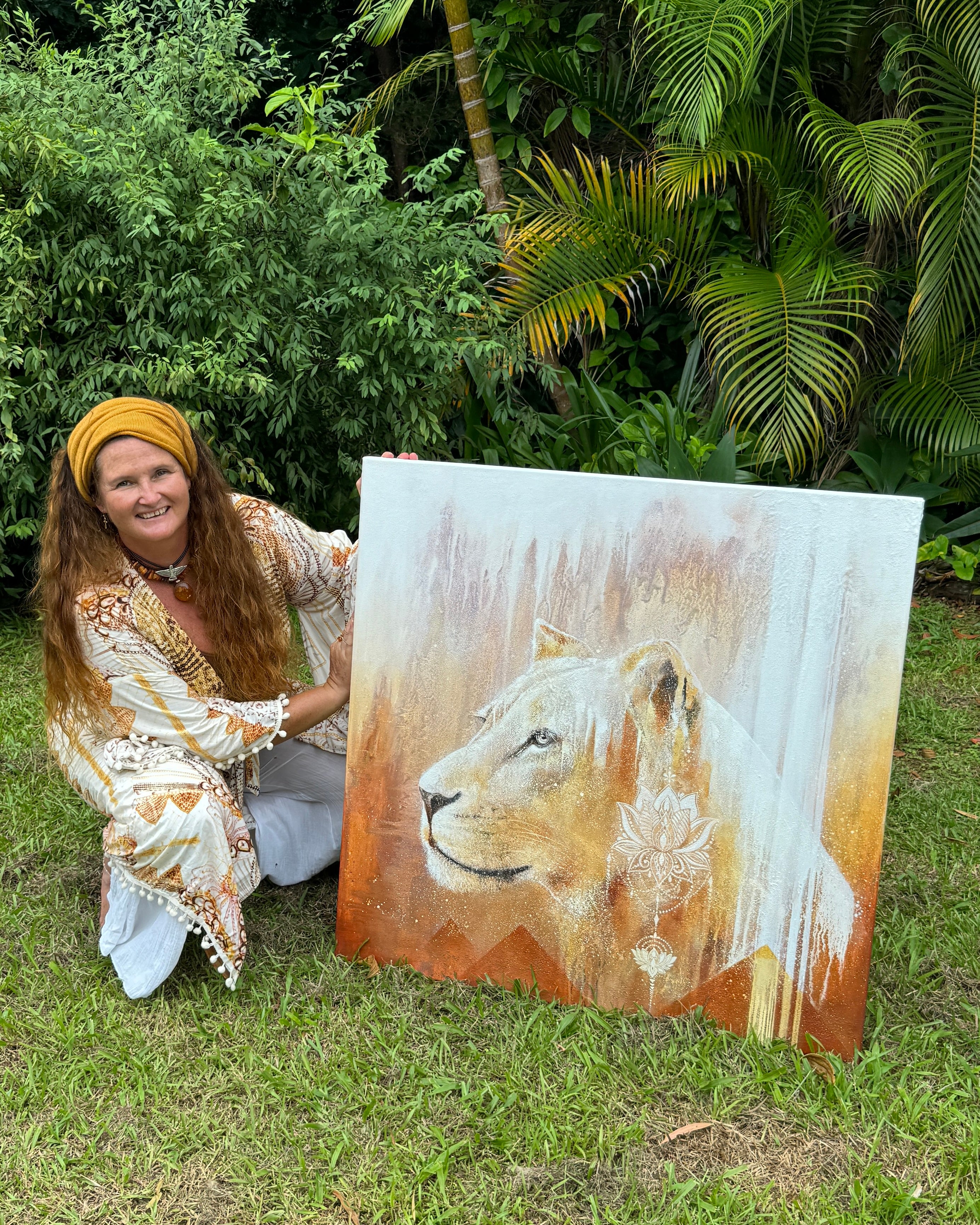 Woman holding a painting of a lion outdoors