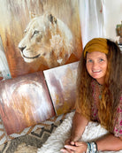 Woman sitting in front of a wall with lion paintings