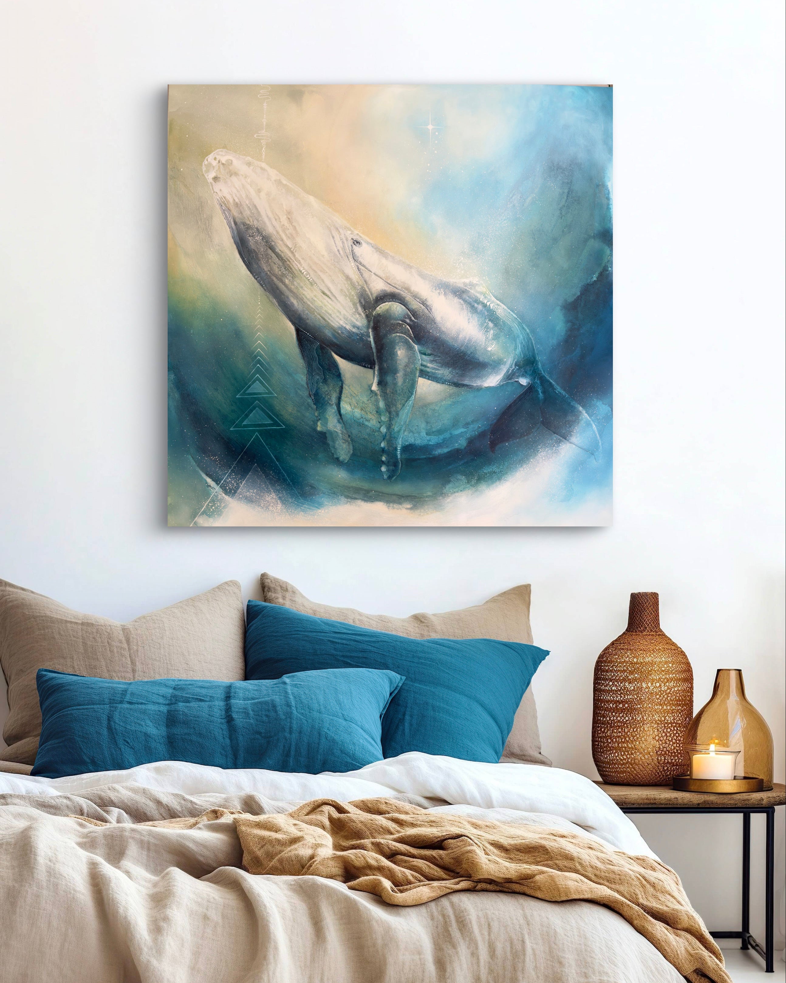 Canvas print of a whale painting above a bed with pillows and a blanket.